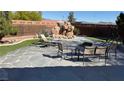 Large backyard with a stone patio, outdoor seating, and decorative rock features providing a peaceful oasis at 9180 Mohawk St, Las Vegas, NV 89139