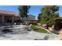 Spacious backyard featuring a stone patio, mature trees, and an outdoor seating area perfect for relaxation at 9180 Mohawk St, Las Vegas, NV 89139