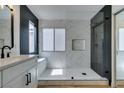 Modern bathroom featuring black and marble tile, a frameless glass shower, and light wood flooring at 9855 Ashton Pines Ct, Las Vegas, NV 89147