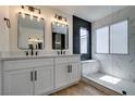 Bathroom featuring a double sink vanity, black fixtures, and a frameless glass shower with black and marble tile at 9855 Ashton Pines Ct, Las Vegas, NV 89147