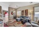 Cozy living room with a patterned rug, grey sofa set, and plenty of natural light at 10372 Timber Canyon Ave, Las Vegas, NV 89129