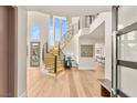 Bright foyer with a curved staircase, light wood floors, and large windows offering ample natural light at 11453 Glowing Sunset Ln, Las Vegas, NV 89135