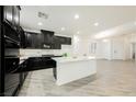 Spacious kitchen with black cabinets, a central island, and modern appliances at 12426 Mosticone Way, Las Vegas, NV 89141