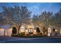 Beautiful home exterior with blossoming trees, manicured lawn, and stone accents at 1610 Brock Ct, Las Vegas, NV 89117
