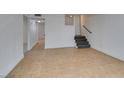 Spacious basement featuring neutral tile flooring, painted walls, and staircase to the main floor at 1806 Renada Cir, North Las Vegas, NV 89030