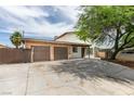 Single-story home featuring a two-car garage, stone accents, and mature landscaping at 1806 Renada Cir, North Las Vegas, NV 89030
