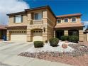 Charming two-story house boasts a three-car garage, desert landscaping, and a cozy front porch at 1904 Imola Ct, Las Vegas, NV 89123