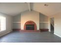 Bright living room with a vaulted ceiling, fireplace, and gray vinyl floors at 1967 N Moapa Valley Blvd, Logandale, NV 89021