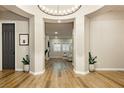 An inviting home foyer featuring wood flooring, a decorative lighting fixture and arched entryway at 2450 Amatrice St, Henderson, NV 89044