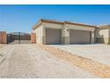 Three-car garage featuring two-tone paint with a gated area on the side for added privacy at 37 Late Harvest Ave, Pahrump, NV 89060