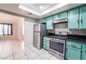 Well-lit kitchen features stainless steel appliances and bright turquoise cabinets at 4036 E Ogden Ave, Las Vegas, NV 89110