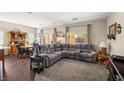 Open concept living area with plush sectional sofa, dark wood floors, and large windows offering natural light at 4937 Semifonte Dr, Pahrump, NV 89061