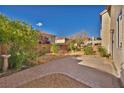 Large backyard with minimal landscaping featuring a brick patio and small garden areas at 5080 Plymouth Bay Ct, Las Vegas, NV 89141
