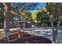 Single-story stone home features double door entry, mature trees, and a wide driveway at 5159 N Monte Cristo Way, Las Vegas, NV 89149