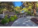 A stone-clad single-story home is adorned with decorative barrels and lush landscaping, enhancing its curb appeal at 5159 N Monte Cristo Way, Las Vegas, NV 89149