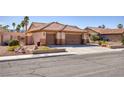 A charming single-story home featuring a three-car garage, desert landscaping, and a tile roof at 5441 Rose Hills St, Las Vegas, NV 89149
