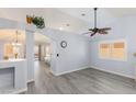 Bright living room showcasing vaulted ceilings, stylish gray flooring, and modern ceiling fan at 5441 Rose Hills St, Las Vegas, NV 89149