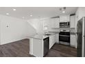 Modern kitchen with stainless steel appliances, white cabinetry, and quartz countertops at 6233 Blood Lily Ave, Las Vegas, NV 89122