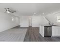 Spacious living room with hardwood floors and carpet, featuring a modern ceiling fan and bright lighting at 6233 Blood Lily Ave, Las Vegas, NV 89122