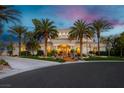 Stately home at dusk with manicured lawn, towering palm trees, and warmly lit exterior; perfect for evening gatherings at 7625 Coley Ave, Las Vegas, NV 89117