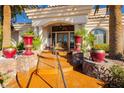 Grand front entrance showcasing a custom doorway, decorative stonework, and colorful plants in ornate pots at 7625 Coley Ave, Las Vegas, NV 89117