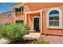 Inviting front entrance with dark green door and well-maintained landscaping at 7920 Aviano Pines Ave, Las Vegas, NV 89129