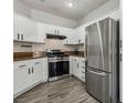 Well-lit kitchen with white cabinetry, stainless steel refrigerator, and modern appliances at 914 Appaloosa Hills Ave, North Las Vegas, NV 89081