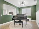 Elegant living room featuring a grand piano, contemporary lighting, and a view to another room at 9557 Belmont Bay Ave, Las Vegas, NV 89148