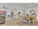 Open-concept living space with tiled floors, white cabinets, and a kitchen island with seating at 9605 Oliver Hills Ave, Las Vegas, NV 89143
