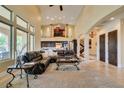 Spacious living room with high ceilings, large windows, and a comfortable leather sectional sofa at 9749 Glistening Brook Ct, Las Vegas, NV 89149