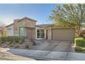 Attractive home featuring a two-car garage, stone accents, and a paved driveway at 9765 Skye Star Ave, Las Vegas, NV 89166