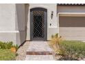 Close-up of front door with decorative security screen and well-maintained landscaping at 12844 New Providence St, Las Vegas, NV 89141