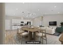 Open-concept living room and kitchen with modern lighting fixtures and wood flooring at 2130 Revere St, North Las Vegas, NV 89030