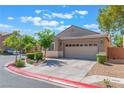Well-kept single-story home featuring a two-car garage, xeriscaping, and manicured bushes at 329 Gemstone Hill Ave, North Las Vegas, NV 89031