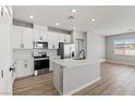 Modern kitchen with white cabinets, stainless steel appliances, and a center island with marble countertop at 4417 Pioche Ave, North Las Vegas, NV 89032