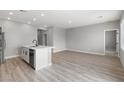 Open-concept living area featuring wood floors, light gray walls, and modern lighting fixtures at 4429 Pioche Ave, North Las Vegas, NV 89032