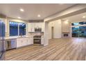 Modern kitchen with stainless steel appliances, white cabinets, and wood-look flooring at 5010 Crooked Stick Way, Las Vegas, NV 89113