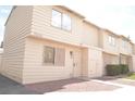 Beige two-story townhome with decorative front door and grated window at 5086 Mountain Vista St, Las Vegas, NV 89120
