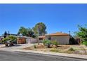 Well-maintained single-story home with desert landscaping and a long driveway leading to a carport at 6225 Rassler Ave, Las Vegas, NV 89107