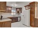 Updated kitchen with white tile floors, herringbone backsplash, stainless steel appliances, and wooden cabinets at 6225 Rassler Ave, Las Vegas, NV 89107
