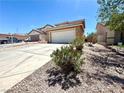 Beige home featuring a large, two-car garage and a concrete driveway with desert landscaping under a bright blue sky at 6287 Stone Hollow Ave, Las Vegas, NV 89156