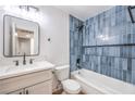 Charming bathroom features blue tile accent wall with shower/tub and updated vanity at 6308 Lawton Ave, Las Vegas, NV 89107