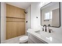 Stylish bathroom featuring wood accent wall, sleek black hardware, and quartz countertop at 6308 Lawton Ave, Las Vegas, NV 89107