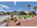 Charming single-story home with manicured desert landscaping, palm trees and a well-kept lawn at 7540 Crystal Cave Dr, Las Vegas, NV 89117