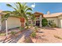 Inviting home entrance featuring a brick walkway, desert landscaping and palm tree at 7540 Crystal Cave Dr, Las Vegas, NV 89117