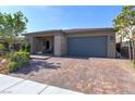 Attractive single-story home featuring a paved driveway, two-car garage, and a welcoming covered entryway at 10049 Cardinal Knoll Ave, Las Vegas, NV 89143