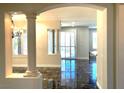 Bright living room featuring black marble flooring and column architecture at 10237 Andante Ct, Las Vegas, NV 89135