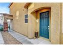 Close-up of front entry with teal door, decorative accents, and gravel lined walkway at 10735 Galveston Bay St, Las Vegas, NV 89179