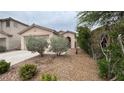Single story home with desert landscaping, covered entry, and attached two-car garage at 10780 Valencia Hills St, Las Vegas, NV 89141