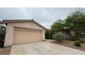 Attached two-car garage with extended driveway and desert landscaping in front of home at 10780 Valencia Hills St, Las Vegas, NV 89141